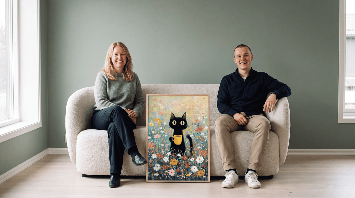 Frida und Jonas, die Kunstexperten von Bozetto, sitzen auf einem Sofa neben einem gerahmten Poster